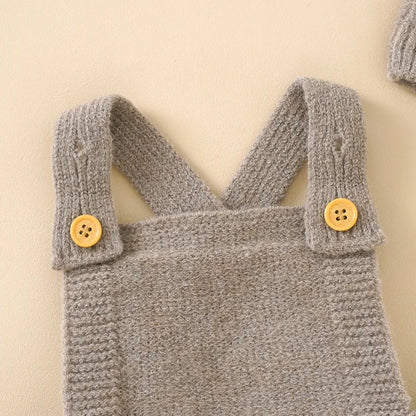 Detailed texture of the acrylic knit on a baby girl's sleeveless romper and hat set