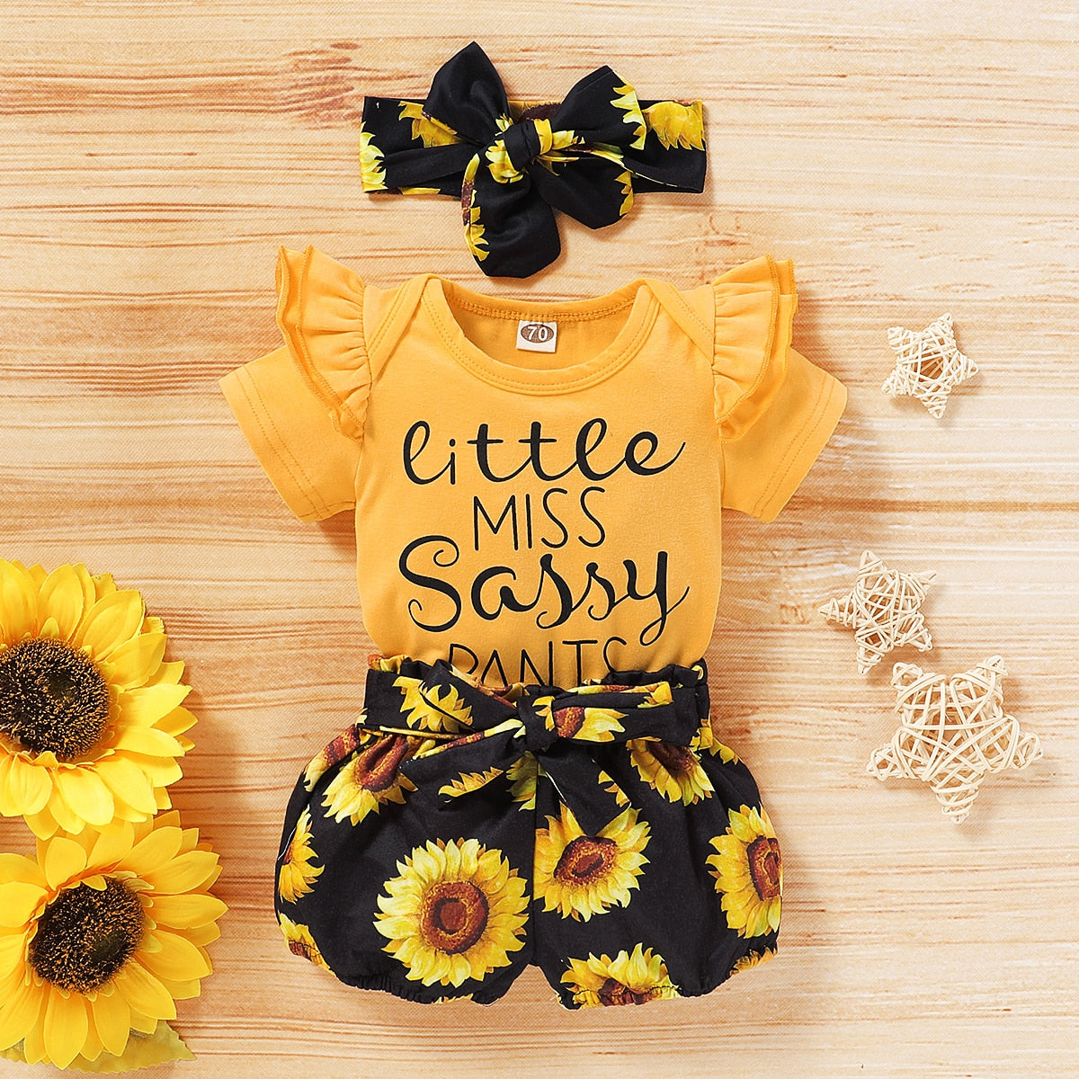 Stylish baby girl's yellow sunflower romper and headwrap, ideal baby fashion for warm weather.