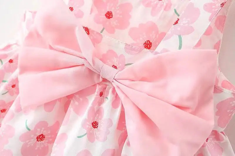 Close-up of the fabric and floral print on a baby girl's summer bow dress, high quality.