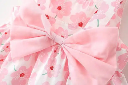 Close-up of the fabric and floral print on a baby girl's summer bow dress, high quality.