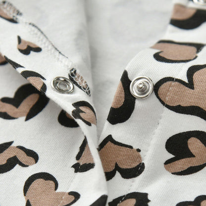 Full view of a baby girl jumpsuit with heart print design and an included headband.
