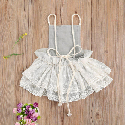 Newborn girl wearing a cute pink lace design romper, perfect for warm weather. Baby clothing.
