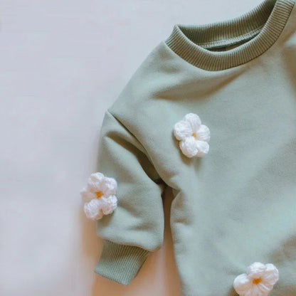 Sweet baby girl looking at camera in a charming floral spring romper, comfortable leisurewear
