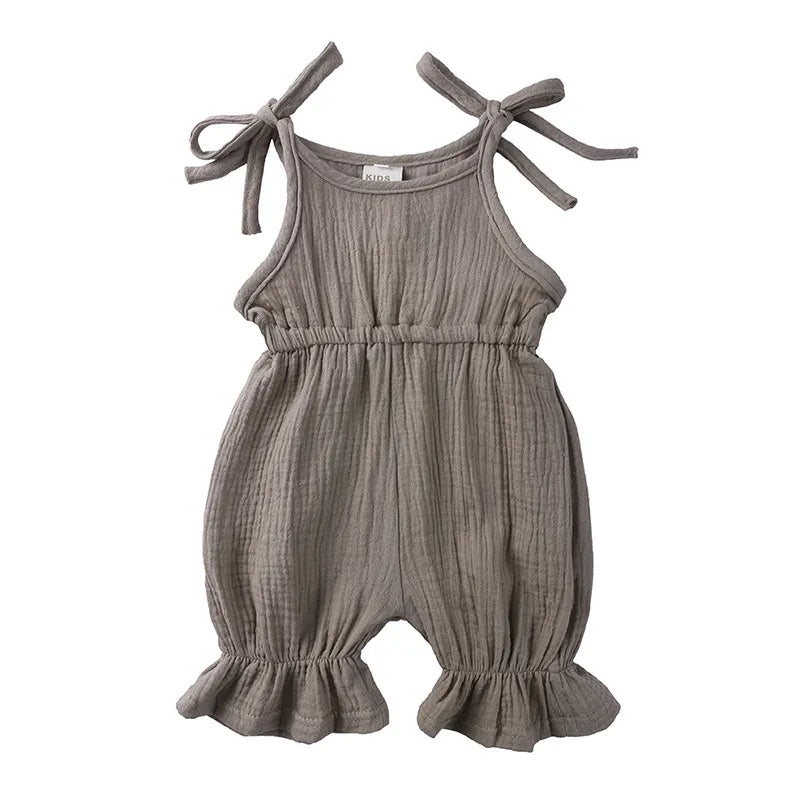 Baby girl's summer outfit: pink cotton sleeveless romper jumpsuit with bow accent.