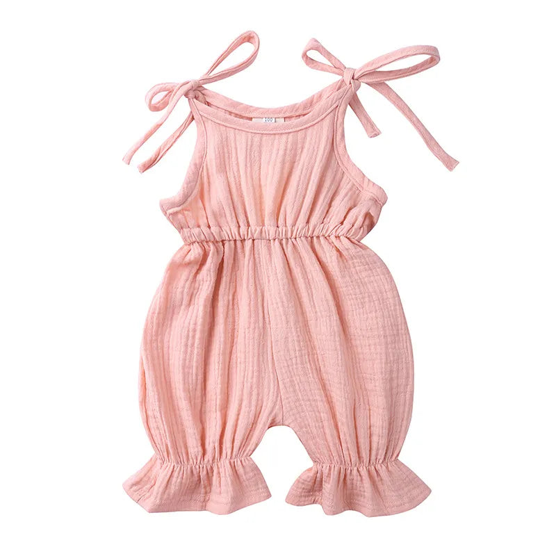 Detail of snaps on the bottom of a baby girl's cotton sleeveless romper for easy changes.