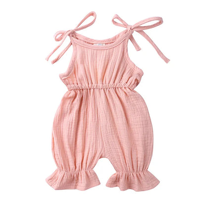 Detail of snaps on the bottom of a baby girl's cotton sleeveless romper for easy changes.