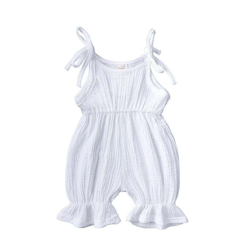 Baby girl reaching up in a cozy cotton sleeveless romper, sweet kidswear.