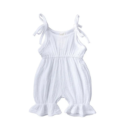Baby girl reaching up in a cozy cotton sleeveless romper, sweet kidswear.