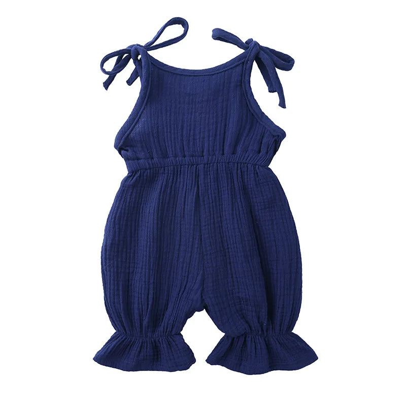 Close-up of a baby girl's cotton sleeveless romper jumpsuit, soft fabric detail.