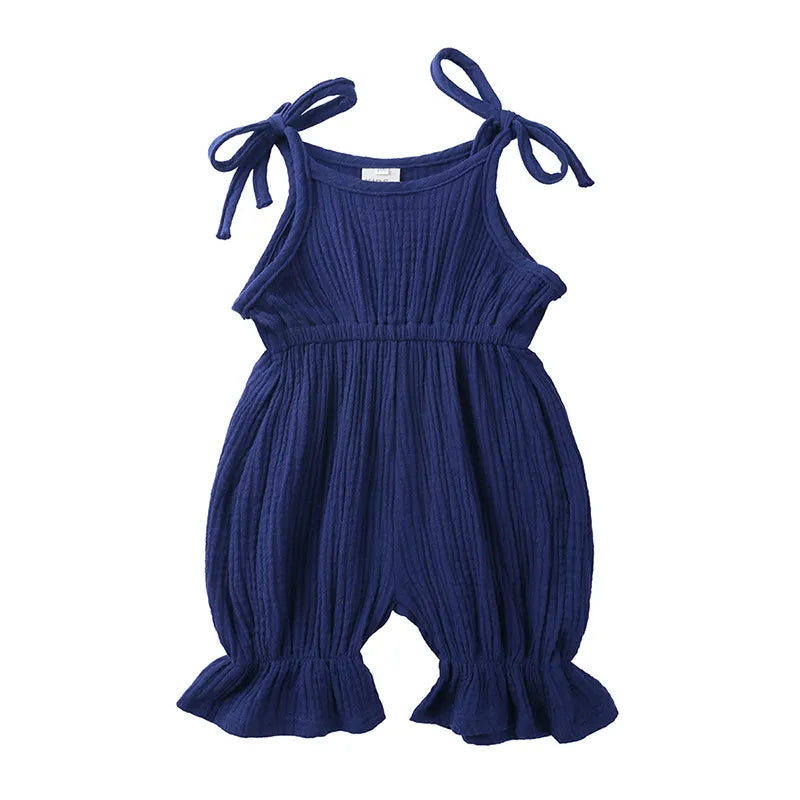Toddler girl exploring in a breathable cotton sleeveless romper, ideal summer playwear.