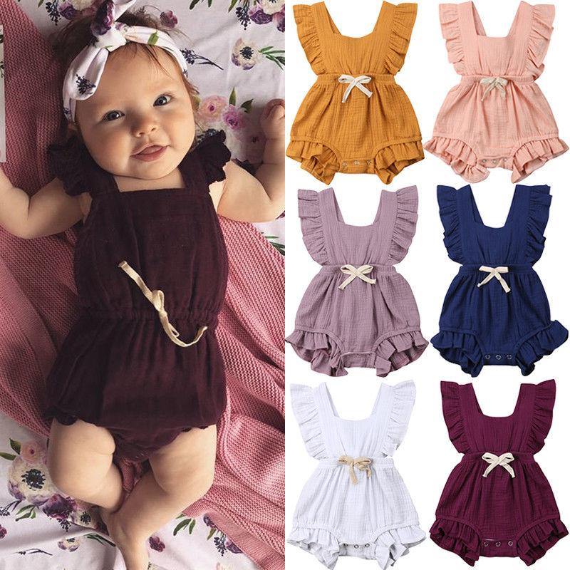 Baby girl in pink frilly ruffle romper with bowknot, natural light, soft focus