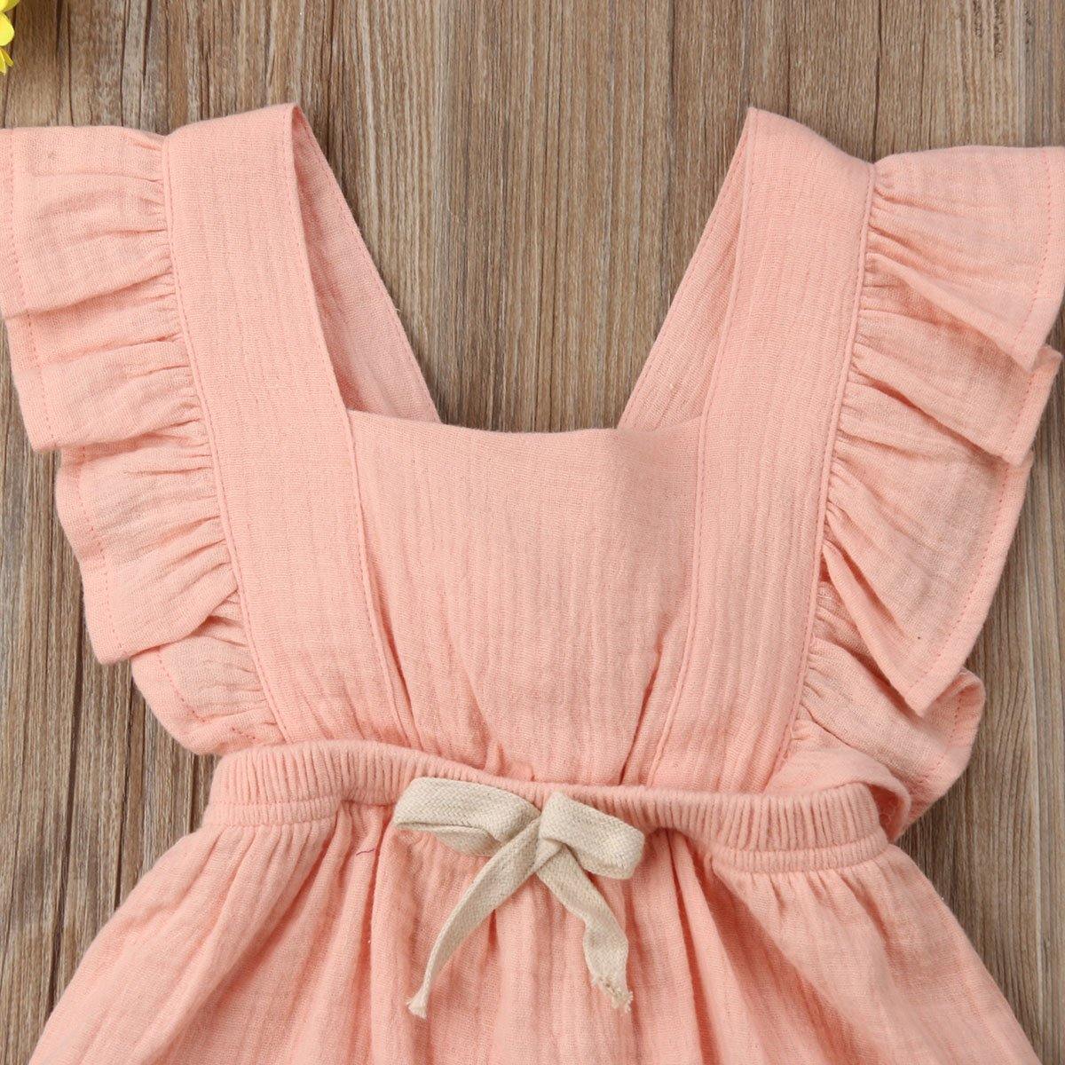 Close-up of pink frilly ruffle romper for baby girl, delicate fabric, bowknot detail