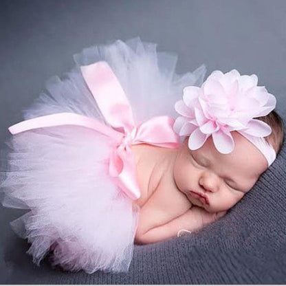 Cute pink layered tulle tutu skirt with an elastic waist and a matching bow headband for infants.