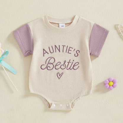 Infant girl sitted in a pink embroidered waffle knit romper, perfect short sleeve jumpsuit for summer.