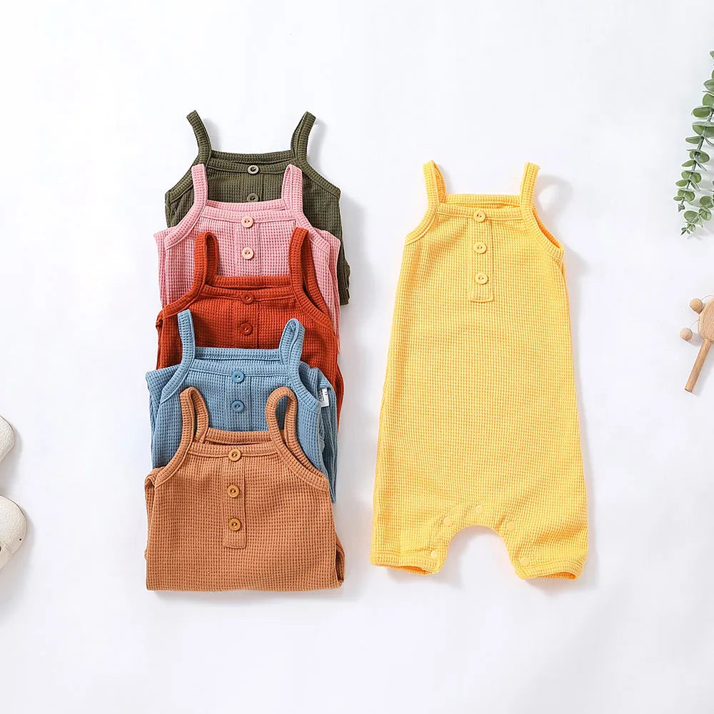 Baby girl in sleeveless cotton romper jumpsuit, pink with floral print, for summer play