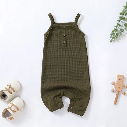 Playtime outfit: baby girl in a sleeveless cotton romper jumpsuit, vibrant green with polka dots