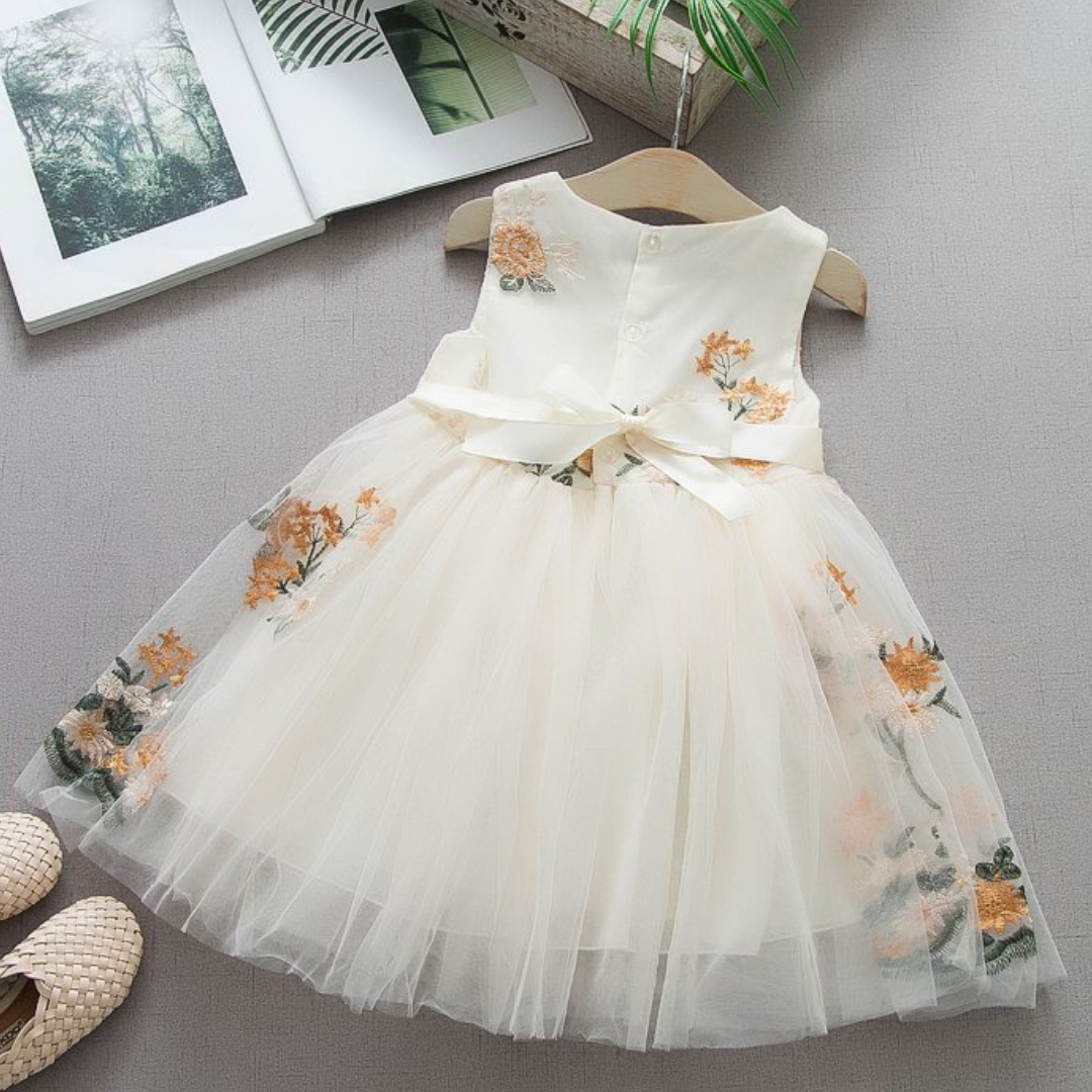 Close-up of floral embroidery on a white girls' princess dress, sleeveless casual design.