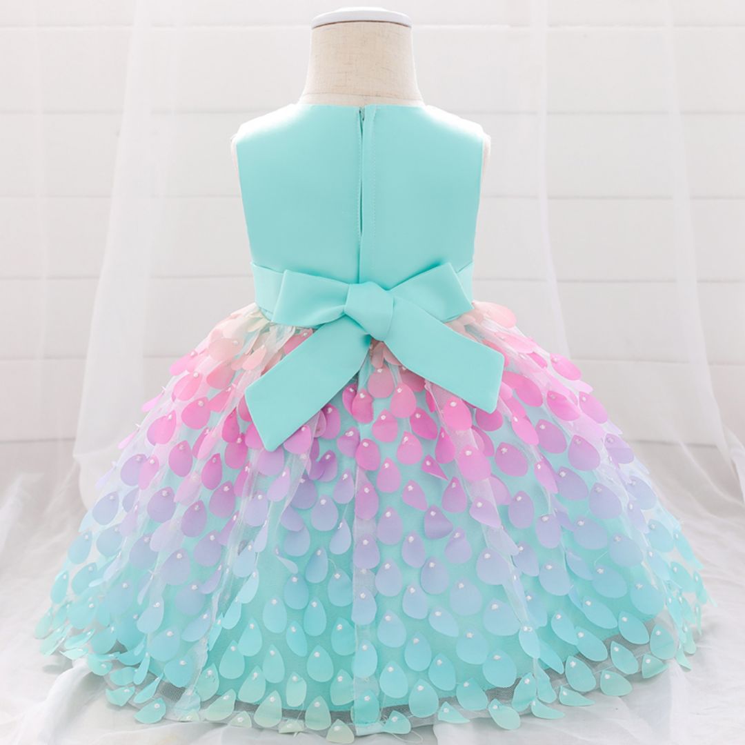 Adorable baby girl wearing a sleeveless mermaid princess dress, blue top, pink petal skirt, baby clothing fashion