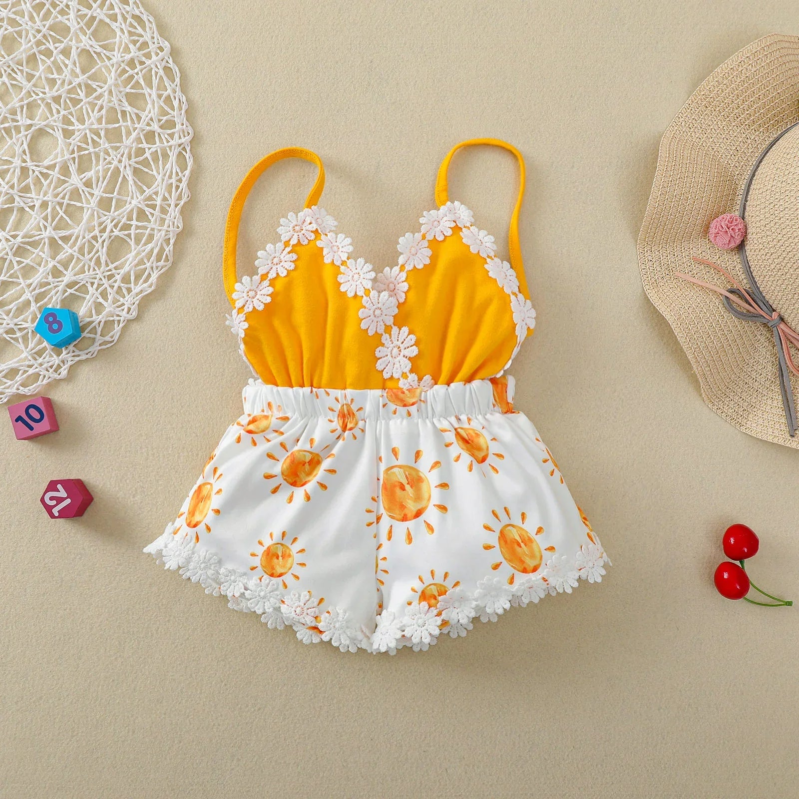 Baby girl in sleeveless sun print romper, light blue with white suns, perfect summer outfit