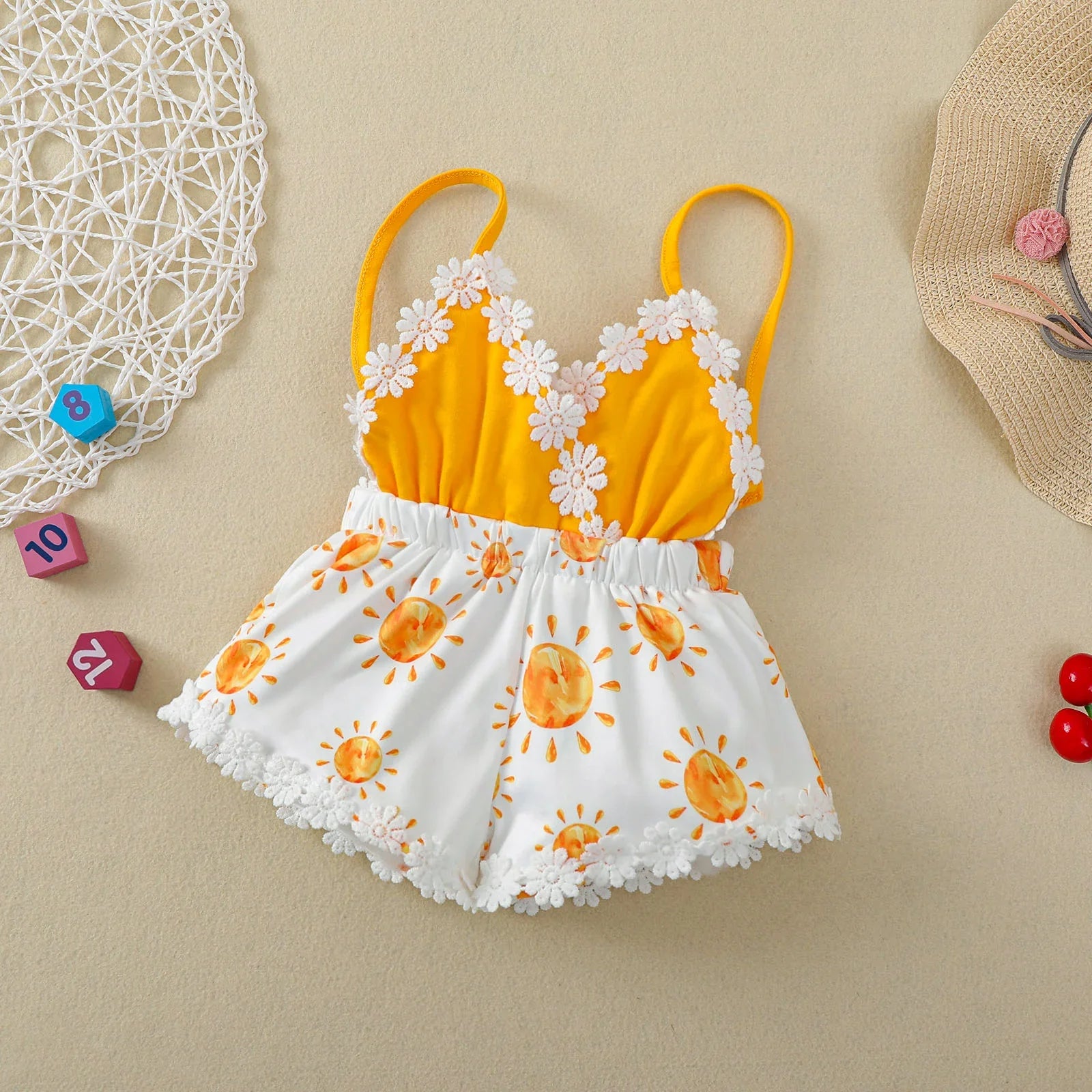 Close-up of sun print fabric on a baby girl's sleeveless romper, soft and comfortable for toddlers