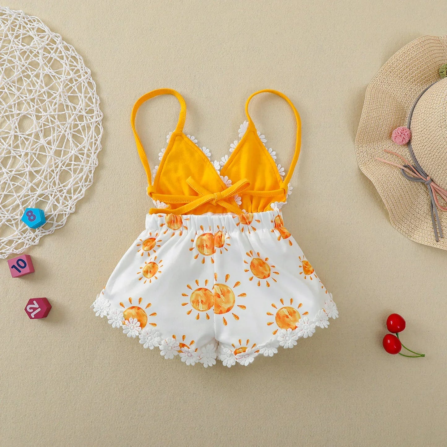 Newborn girl wearing an adorable sun print jumpsuit, ideal for summer playwear