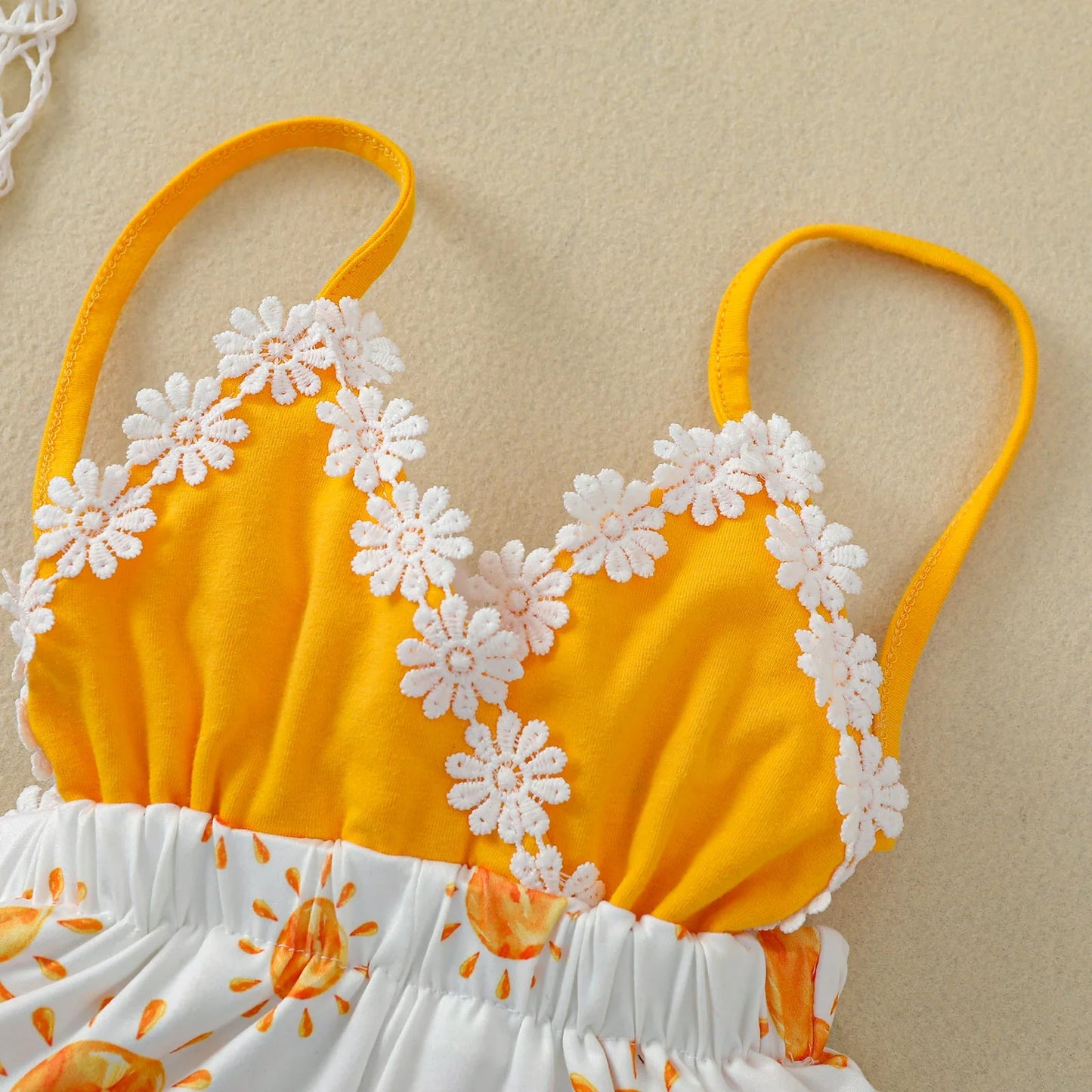 Back view of a baby girl's sleeveless romper with cheerful sun print pattern, toddler fashion