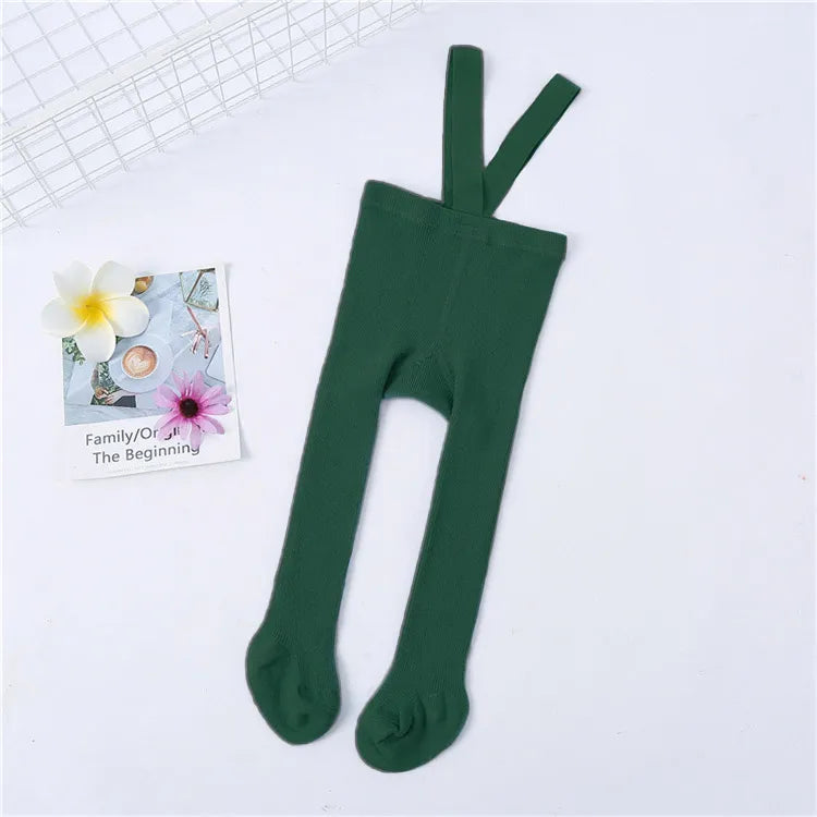 Cute baby in patterned knit tights with shoulder straps, a charming detail for toddler fashion.