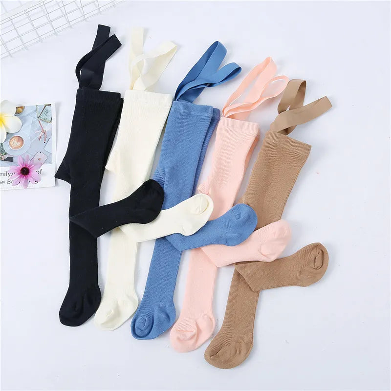 Close-up of soft grey knit tights with shoulder straps for baby girls, showcasing quality fabric.