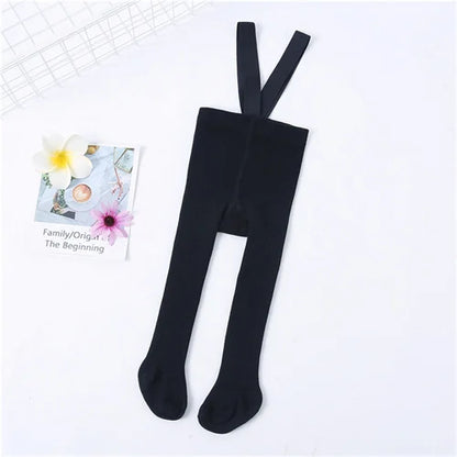 Stylish baby girl in white knit tights with shoulder straps, a classic addition to her wardrobe.