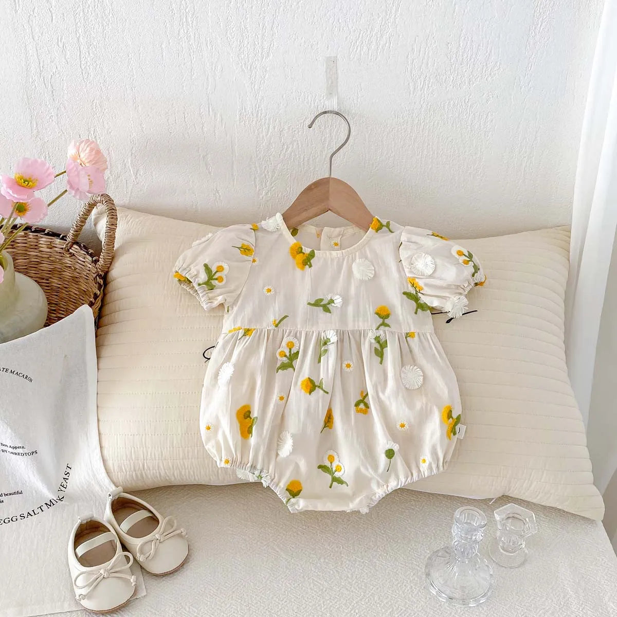 Baby girl in white floral embroidered jumpsuit, short sleeve, perfect for summer.