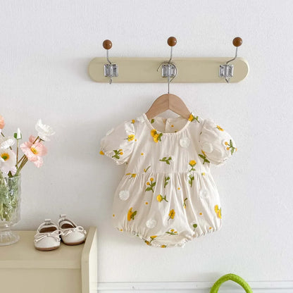 Newborn girl wearing a soft cotton embroidered floral short sleeve jumpsuit.