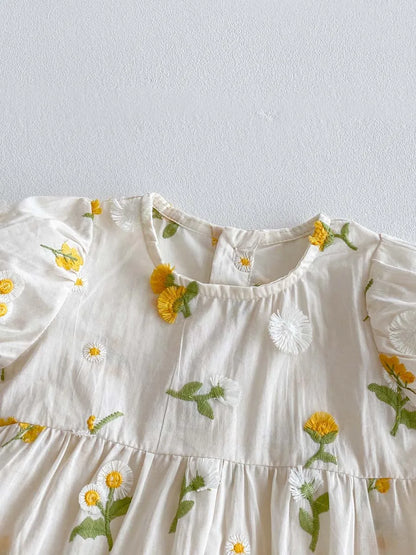 Toddler girl's summer outfit: white embroidered floral jumpsuit with short sleeves.