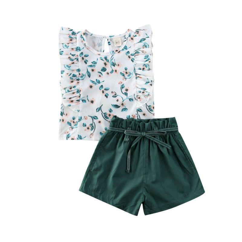 Flat lay of girls' floral frilly top and green shorts set, perfect kidswear for summer