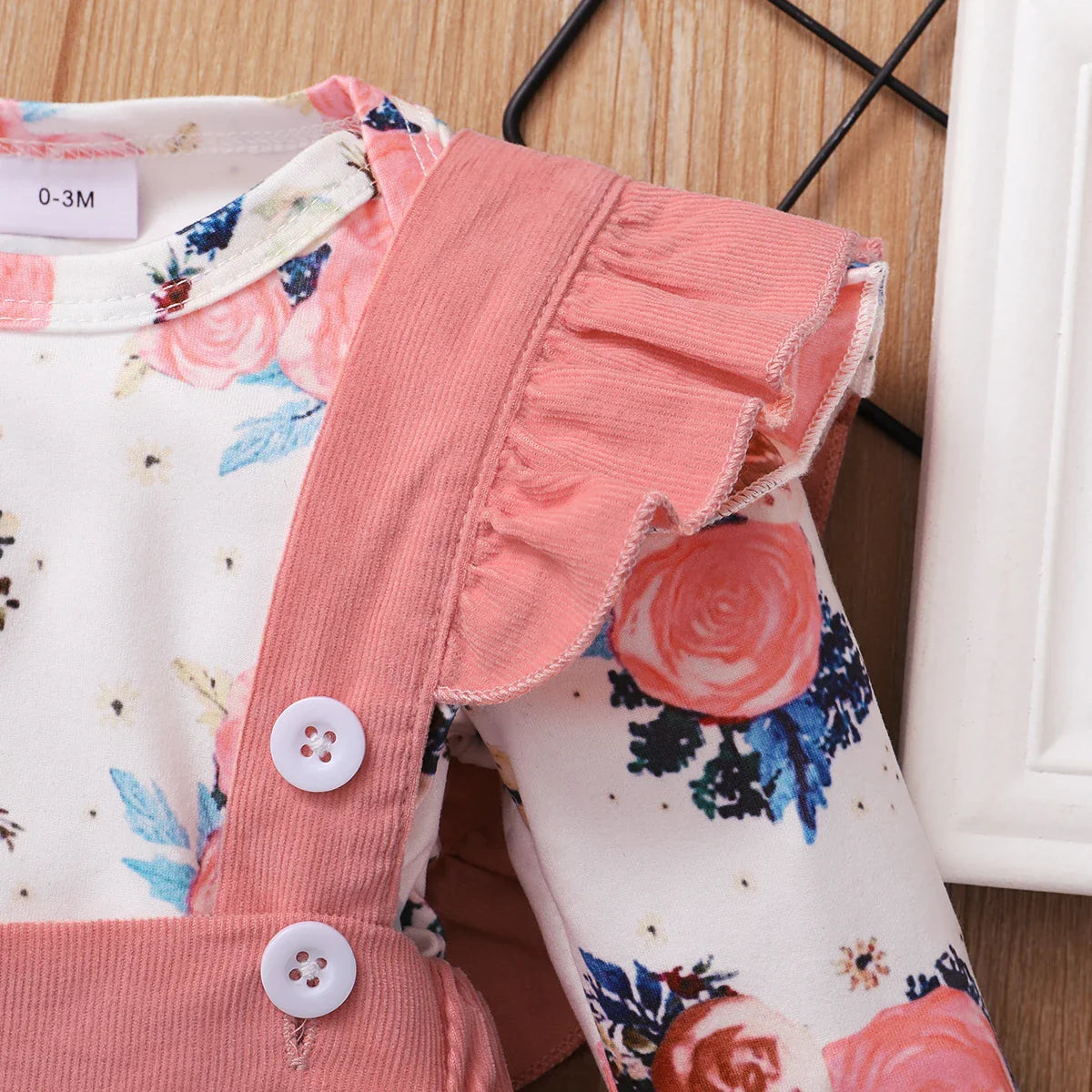 Textured brown suspender skirt for baby girls, paired with a soft floral print romper.