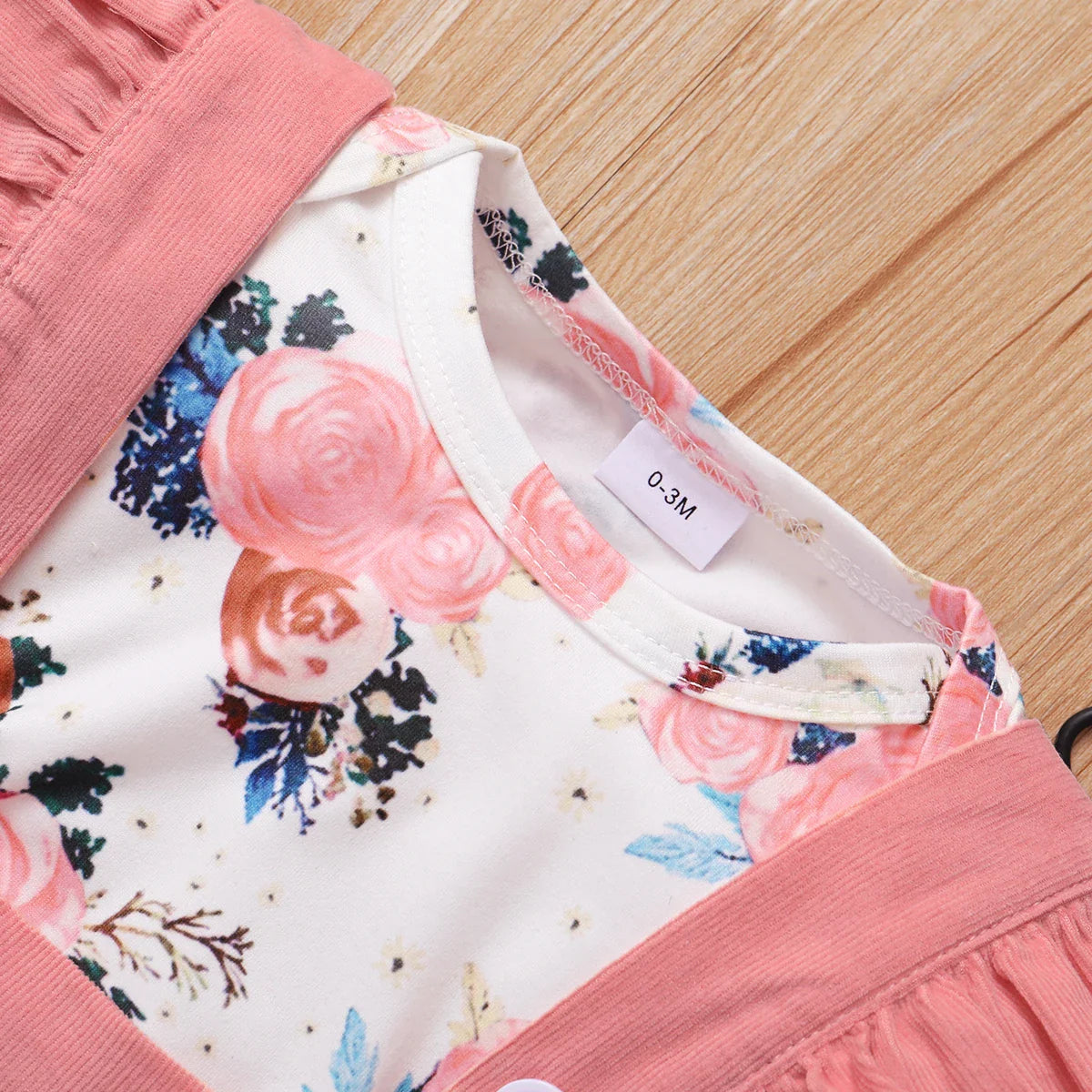 Newborn baby girl outfit: white floral top romper paired with an adorable brown pleated skirt.