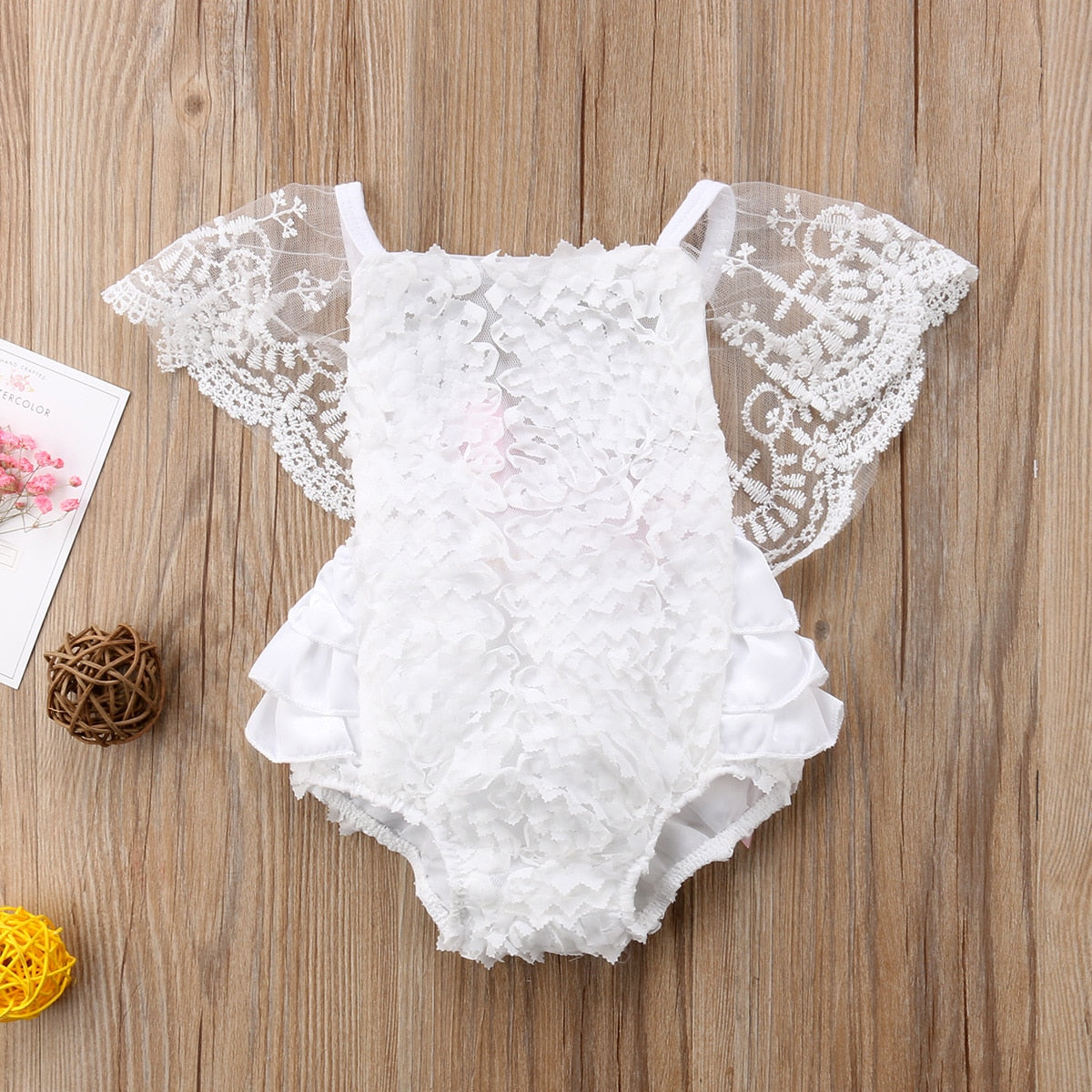 Infant girl modeling an elegant white lace princess bodysuit dress, ideal for special occasions or as a baby gift.
