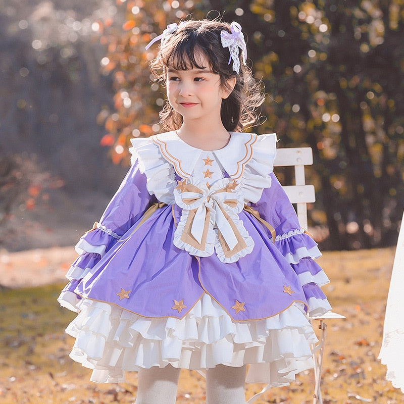 Detail of a baby girl's long sleeve lace ruffle dress, showcasing the soft cotton material