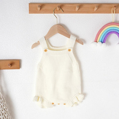 Full shot: baby girl wearing a cozy pink knitted romper, perfect summer outfit