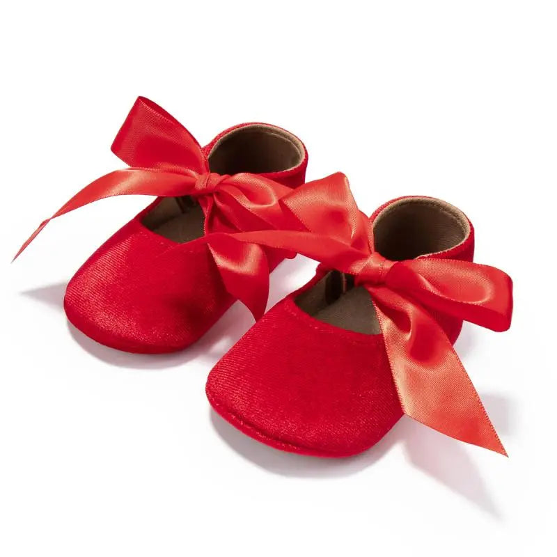 Pair of baby girl pink first walker shoes with butterfly knots and soft soles for infants