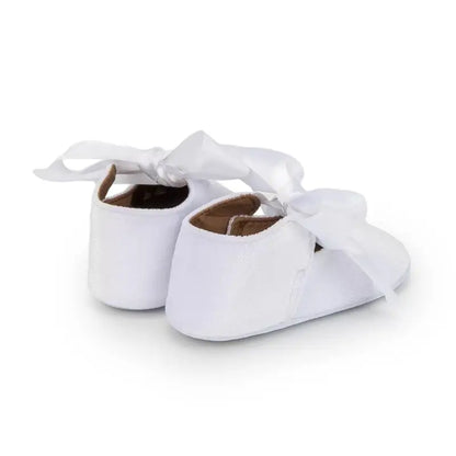 Top view of pink baby girl princess shoes with a butterfly knot and soft flexible sole