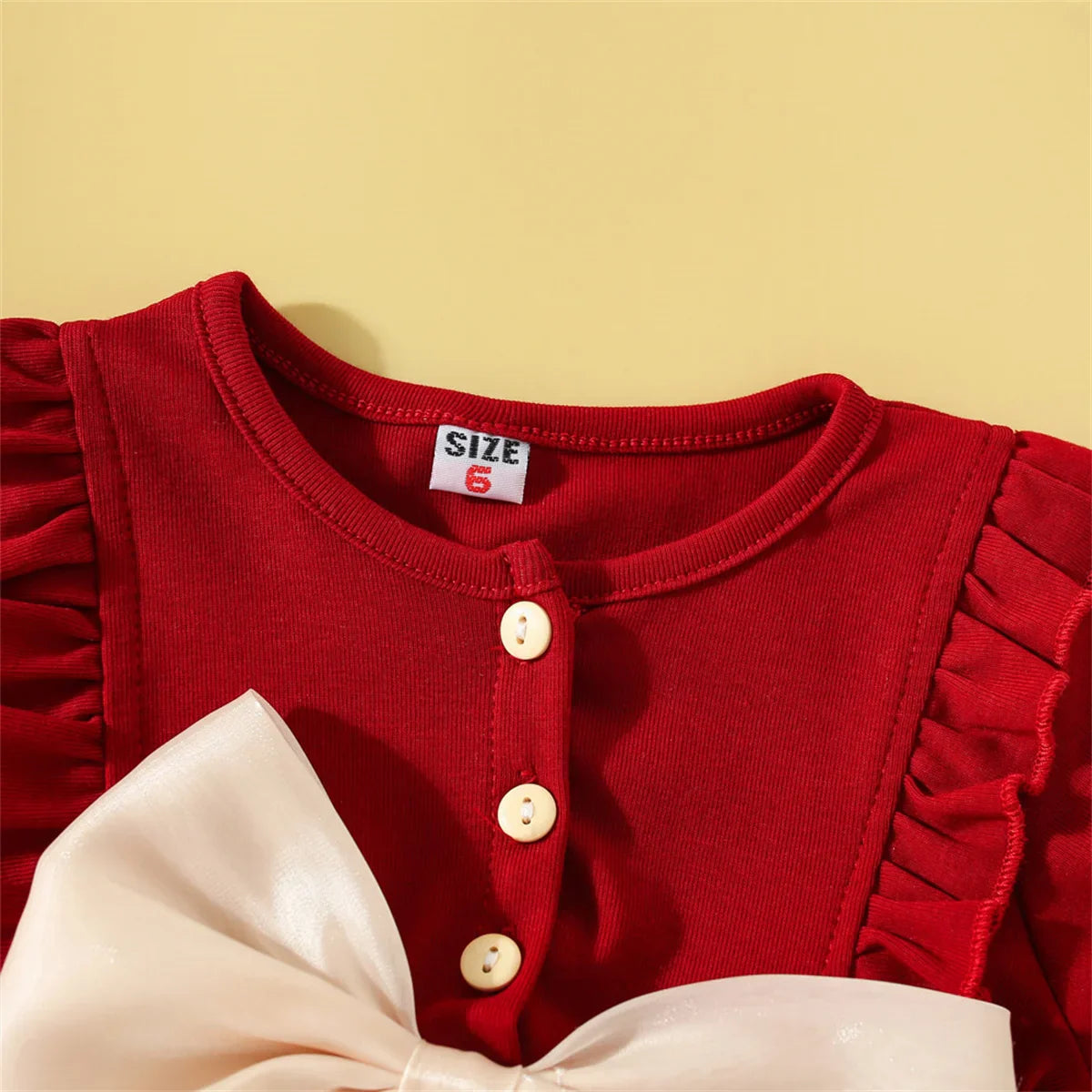 Close-up of the delicate mesh fabric on a baby girl's summer cotton dress with bow
