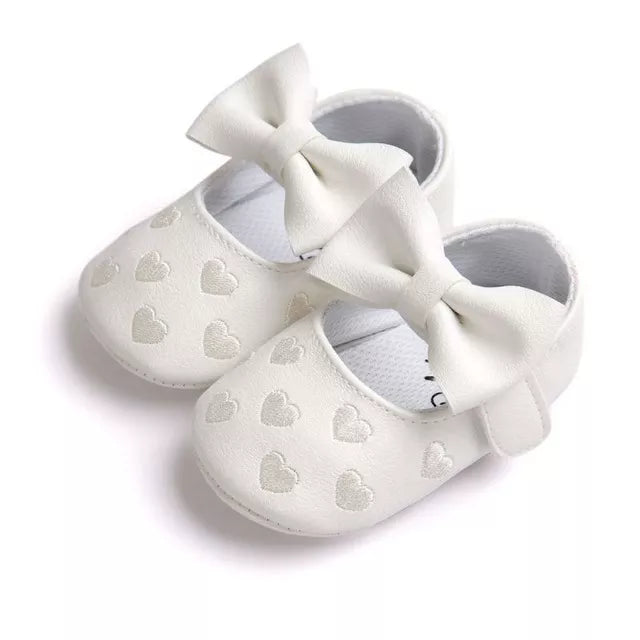 Side view of soft PU leather baby girl moccasins with heart design, infant crib shoes