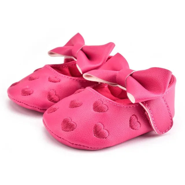 Pink baby girl crib shoes with heart print and bow, soft PU leather moccasins for infants