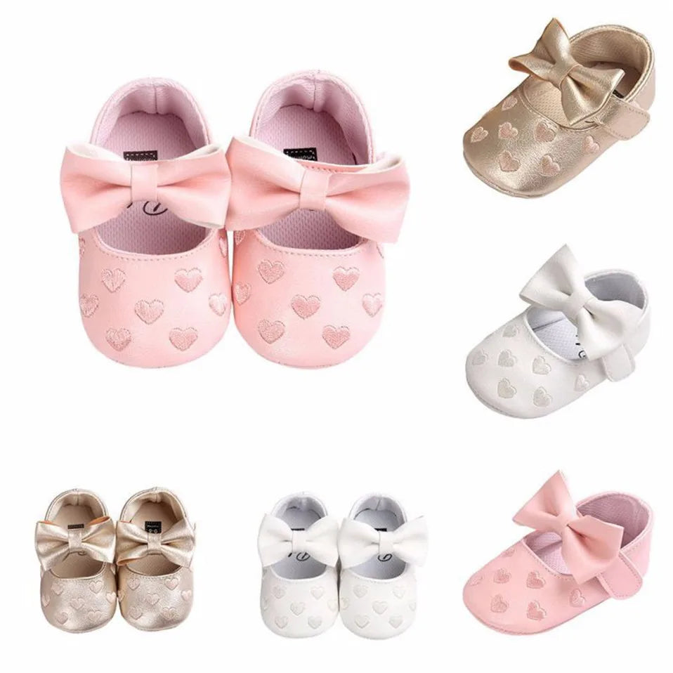 Soft baby girl moccasins in pink with heart graphics, slip-on style for newborns