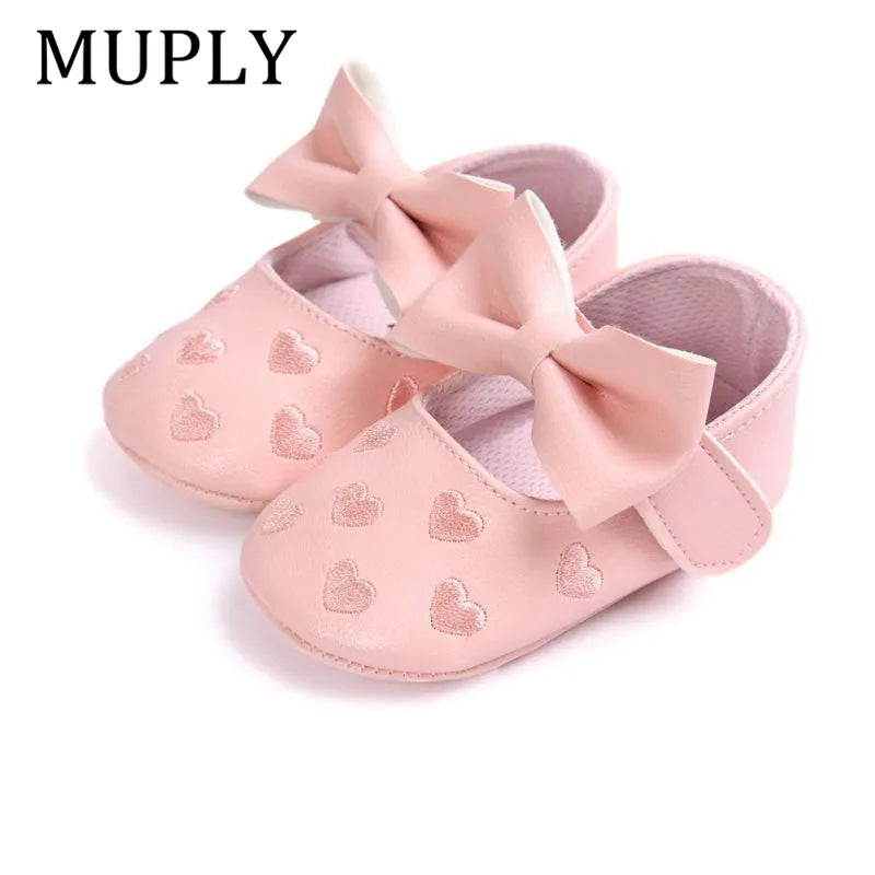 Pair of pink PU leather baby moccasins with heart design, ideal newborn prewalker shoes
