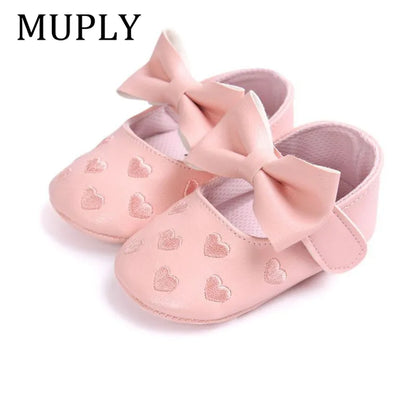 Pair of pink PU leather baby moccasins with heart design, ideal newborn prewalker shoes