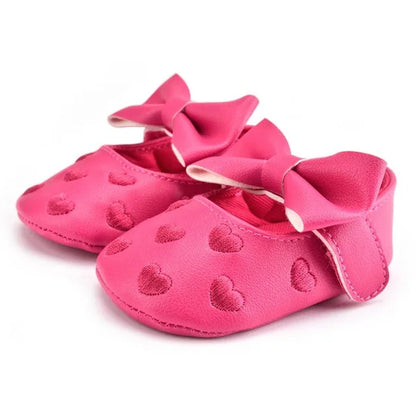 Infant girl prewalker moccasins, with heart design and bow, providing soft support
