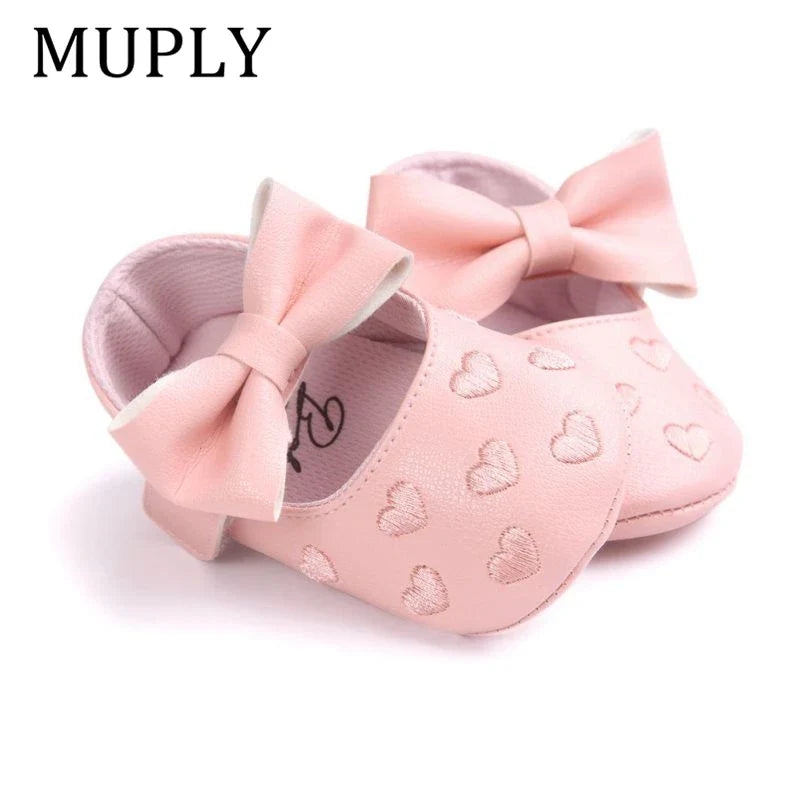 Adorable baby girl moccasins with heart pattern and bow detail, soft crib shoes for infants