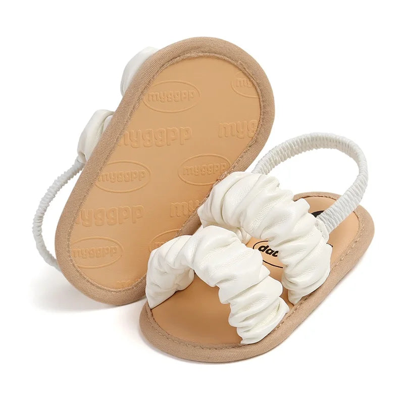Infant girl soft sole sandals in white, anti-slip design for baby's first steps.