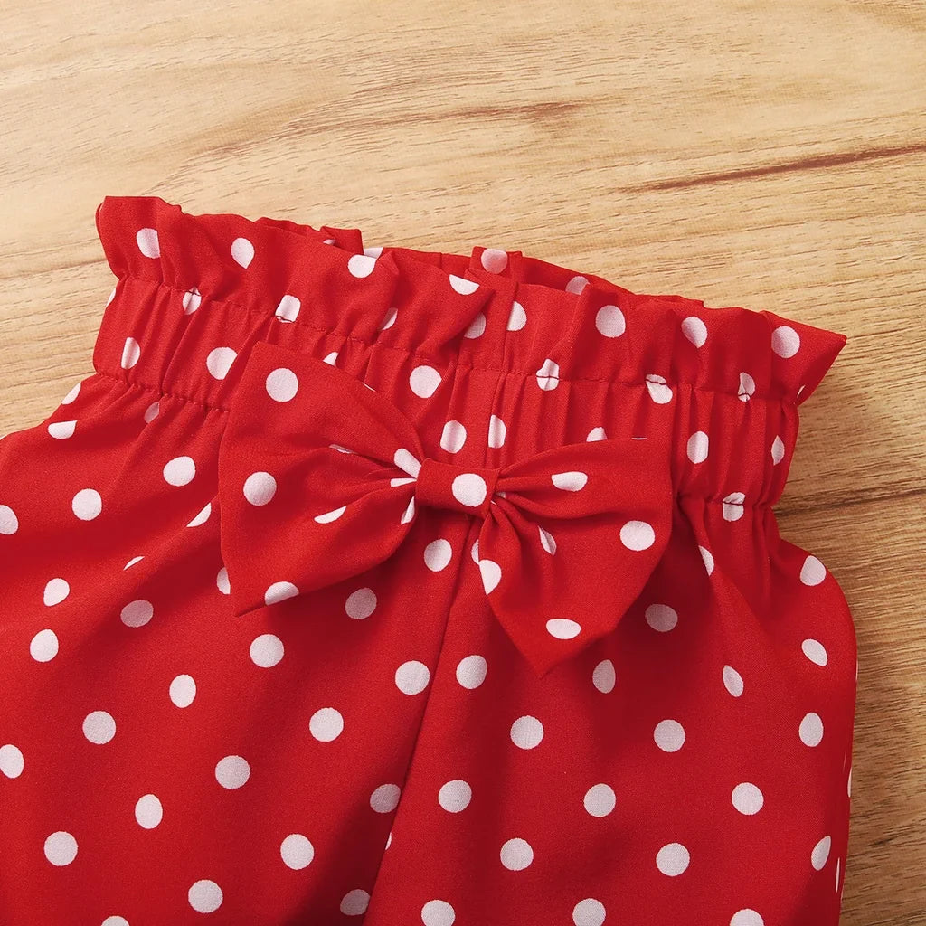 Detailed image of the combed cotton fabric in a red polka dot baby girl bodysuit set
